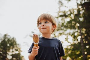 Young boy holding an ice cream cone outdoors