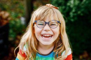 Laughing girl with glasses and blonde hair