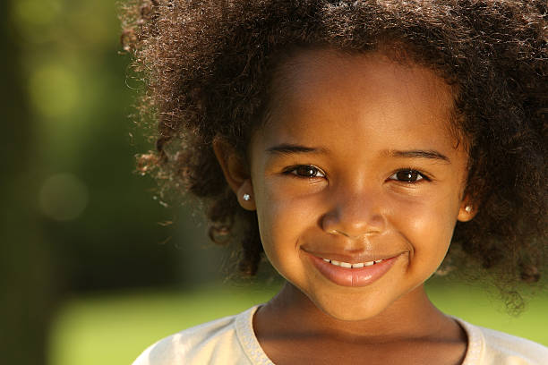 Smiling young girl with curly hair outdoors
