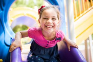 Happy girl on a slide at a playground