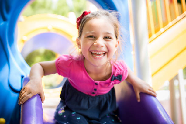 Happy girl on a slide at a playground